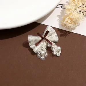 Vue rapprochée du patch nœud en dentelle beige élégant avec ruban marron et perles.