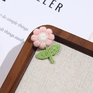 Close up detail view of cute pink and green fabric flower embroidery patch clothing accessory