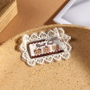 Detailed close-up of cute bear lace patch, exquisite bow embroidery, ideal for DIY crafts.