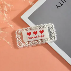 White lace embroidery patch with sweet red hearts and cute fabric label for DIY crafts.