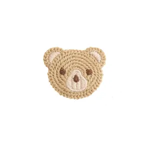 Close-up detail of cute bear embroidery patch, delicate woven texture for DIY handmade accessories.