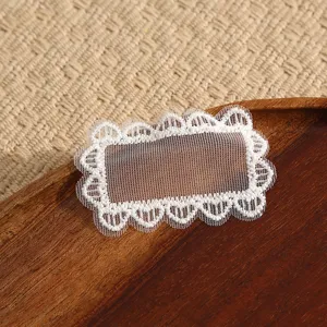White lace patch detail, delicate embroidery trim for DIY clothing repair and decoration.