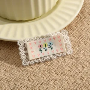 Close-up of cute floral embroidered lace fabric patch DIY clothing accessory with delicate details.