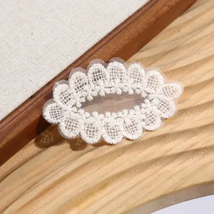 Gros plan détail de l'application de broderie de dentelle florale blanche pour couture DIY.