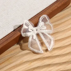 Gros plan sur les détails de la broderie de nœud en dentelle blanche avec artisanat délicat.