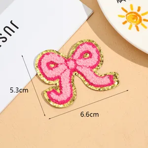 Pink bow embroidered patch with gold glitter edge, perfect for clothing DIY and decoration.