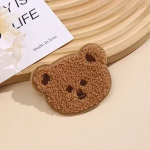 Detailansicht des braunen flauschigen Bärenstickerei-Patches, niedliches Plüsch-Accessoire.