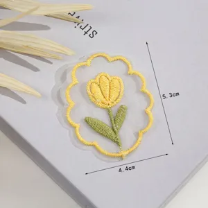 Detail view of yellow tulip embroidered cloth patch, featuring delicate stitching for DIY crafts.