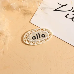 Close-up detail of oval lace embroidered woven clothing label patch with clean design.