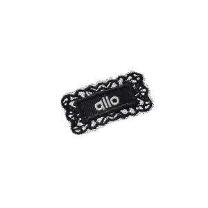 Black lace embroidered patch detail, delicate woven label accessory with white allo lettering.