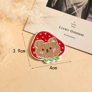 Detailed close-up view of a cute brown bear and red strawberry embroidered patch item.