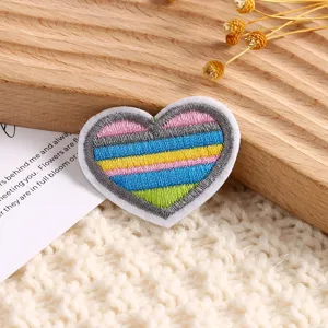 Détail d'un patch brodé cœur rayé coloré pour les vêtements, loisirs créatifs et écharpes.