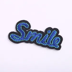 Smile embroidery patch detail view, blue script design for clothing DIY and denim decoration.