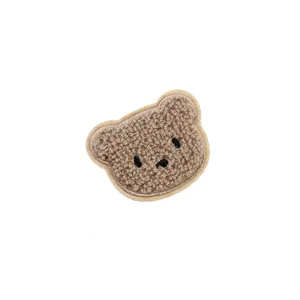 Detailed close-up of fluffy bear plush patch, perfect for clothing and DIY decorative crafts.