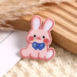 Close-up detail of cute pink cartoon rabbit embroidery patch for clothing DIY decoration.