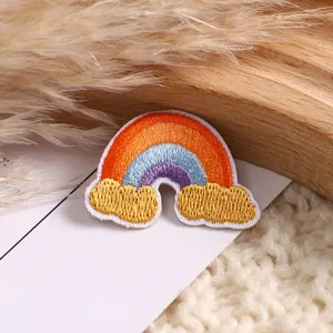 Rainbow embroidered patch detail, colorful DIY clothing accessory close up view for jacket jeans.