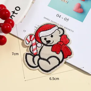 Close-up detail shot of the cute Christmas bear embroidered patch with candy cane and bow.