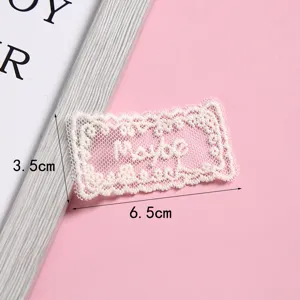 Toppa in tessuto di pizzo bianco con motivo a griglia, ideale per decorare accessori abbigliamento.