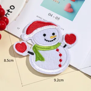 Close-up detail of a cute Christmas snowman embroidered patch featuring a red Santa hat and scarf.