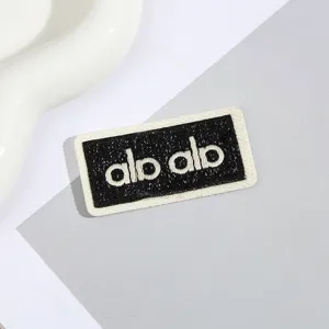 Nahaufnahme eines schwarz-weißen bestickten Alphabet-Aufnähers mit sauberen Stichen.