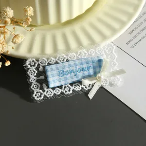 Close-up detail of blue and white plaid embroidered lace fabric patch DIY garment accessory