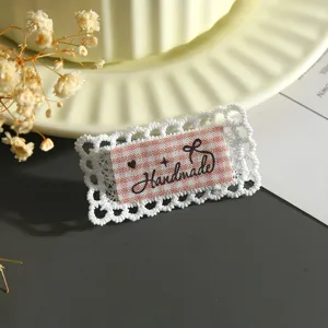 Handmade lace fabric patch DIY accessory detail close up white and pink grid design