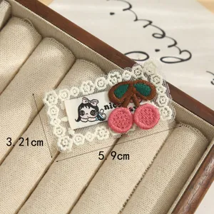 Vintage lace border embroidered patch with cute cartoon girl and pink cherry design for DIY crafts.