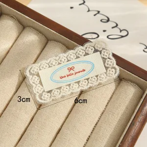 Detailed close-up of vintage lace embroidery patch with cute bow design for DIY crafts.