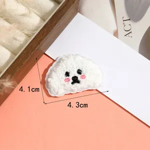 Nahaufnahme Detail des niedlichen flauschigen Hunde Cartoon Handtuch Stickerei Aufnähers, feine Textur.
