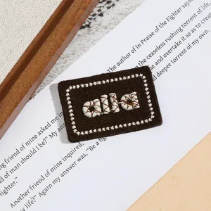 Brauner bestickter Buchstaben-Stoffaufnäher, DIY-Dekoaccessoire für Kleidung und Taschen.