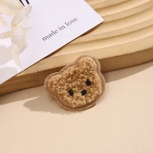 Nahaufnahme eines flauschigen Teddybär Bestickung Aufnähers, niedliches Plüsch Zubehör Detail.