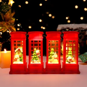 Close-up of glowing Christmas telephone booth night lights with mini snowmen and trees.