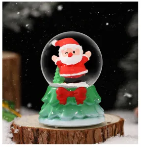 Christmas snow globe decoration featuring cute Santa Claus on tree base for holiday desktop decor.