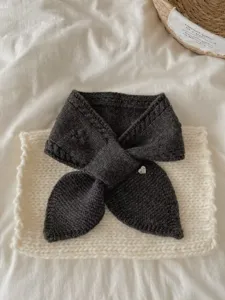 Detailed shot of dark grey knitted scarf, soft texture, cozy winter neck warmer flat lay.