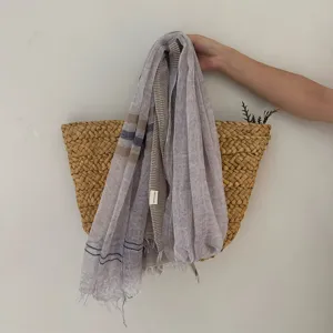 Close-up detail of lightweight striped linen blend scarf with fringe design, artistic retro style.