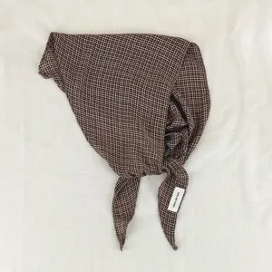 Close-up detail of the brown houndstooth diamond scarf showing texture and brand label design.