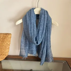 Blue lightweight fringe scarf detail shot showing soft breathable fabric texture and edges.