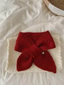 Cozy red knitted short scarf detail, soft cable knit texture with cute heart charm accessory.