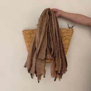 Detail shot of a retro striped linen scarf with frayed edges, soft texture and rustic style.