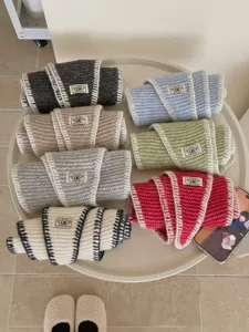 Detailed view of early autumn knit locked-edge diamond scarves in multiple vibrant colors neatly rolled.