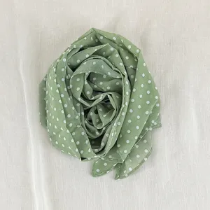 Green polka dot silk scarf detail, elegant lightweight fabric necktie, stylish spring ribbon.