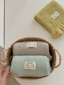 Soft ribbed knit scarf detail featuring cozy texture, cute cloth label, and fresh colors.
