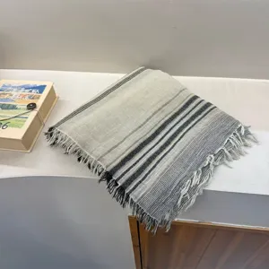 Cozy striped scarf with frayed fringe edges, soft neutral tones, perfect winter warm fashion accessory.