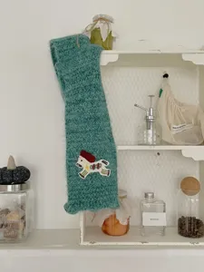 Detailed view of the knitted pony scarf, showcasing cozy green texture and cute embroidered pony.