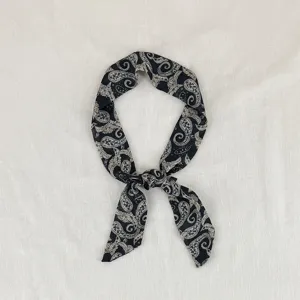Primo piano dettagliato di una sciarpa sottile con stampa paisley nera vintage, nastro.
