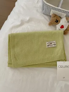 Cozy knit scarf with woven patch detail, soft and warm solid color winter accessory for women.