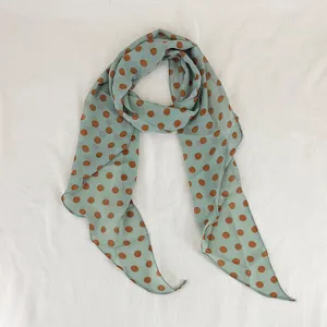 Detailed view of sage green and brown polka dot silk scarf for summer neckwear decoration.