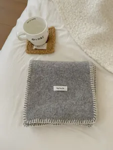 Acogedora bufanda de punto gris gruesa de invierno con borde blanco, accesorio de moda.
