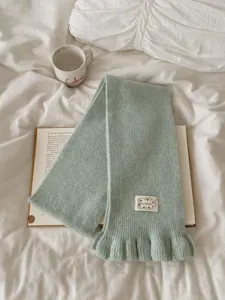 Green knit scarf for women, cozy winter tassel scarf with ruffles and cute label detail.