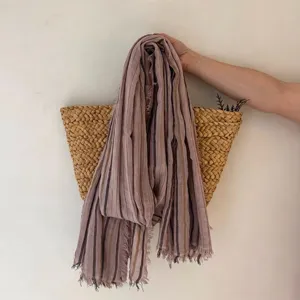 Gros plan d'un foulard rayé rétro avec franges, montrant la texture et le beau tombé naturel.